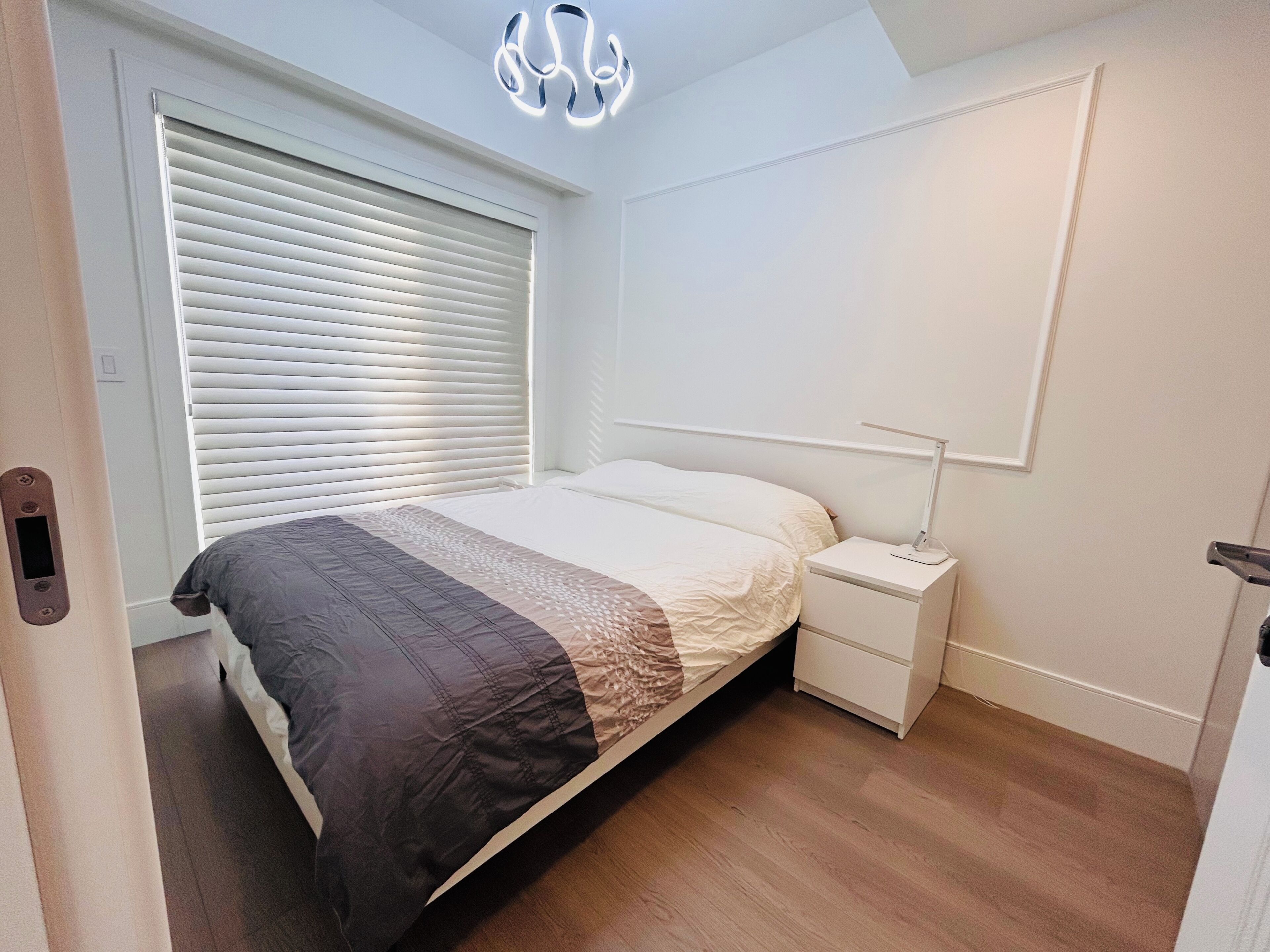 Ein Schlafzimmer mit Bett, Nachttisch und einer Wandleuchte.