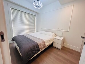 Ein Schlafzimmer mit Bett, Nachttisch und einer Wandleuchte.