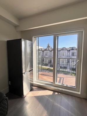 A room with a large sliding glass door leading to an outdoor patio area. - Modern Spacious 2 Bed 2 Bath Townhouse (Vancouver)