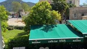 A Heineken cafe bar with outdoor seating, a stone building in the background, and a mountain view. - Ston Heritage Apartment with City view (Ston)