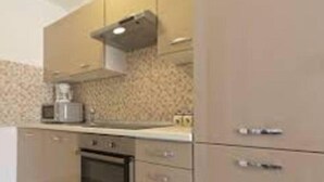 Una cocina con microondas, horno y armarios.