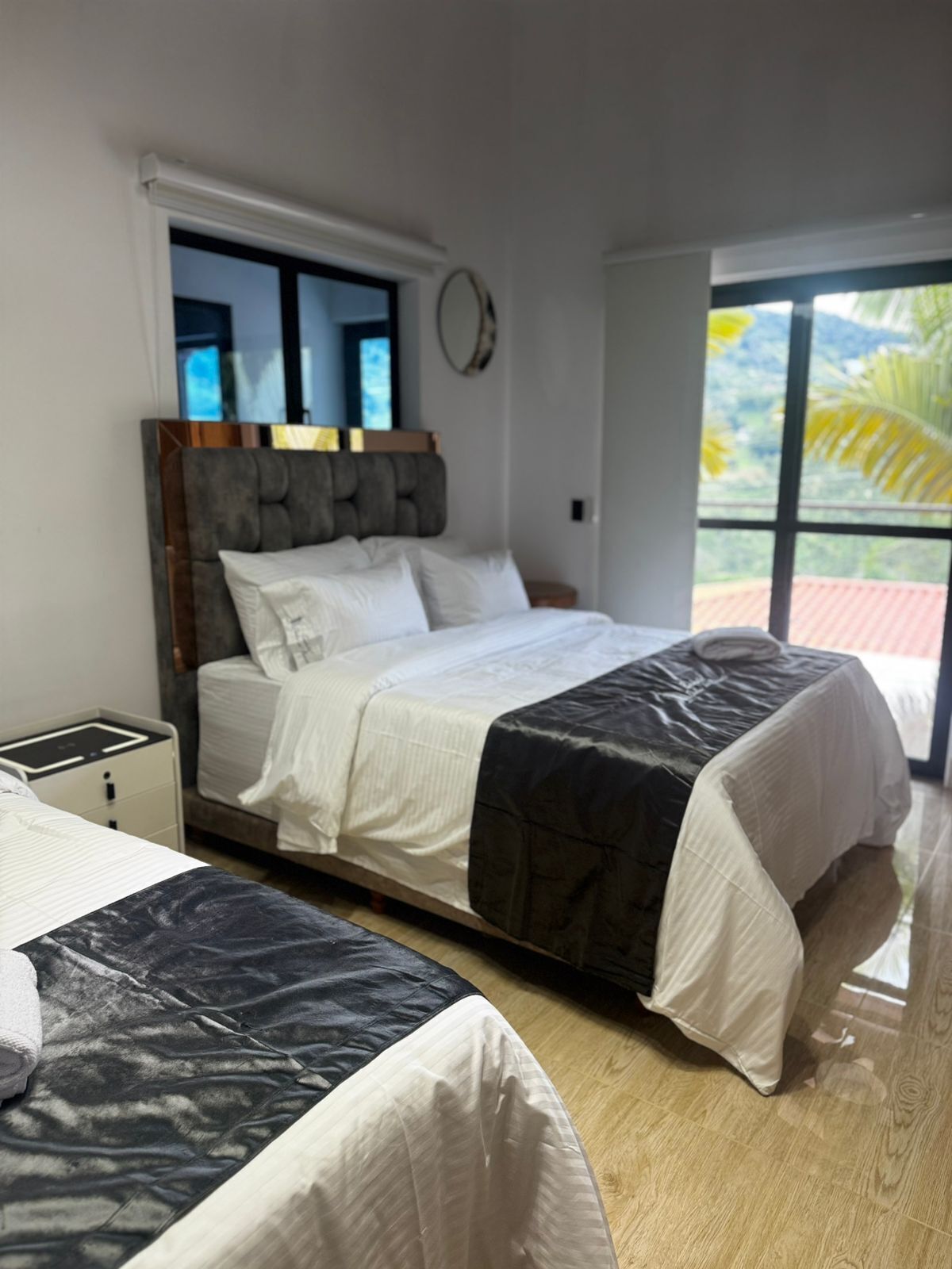 Un dormitorio con cama, mesita de noche y ventana con vistas.
