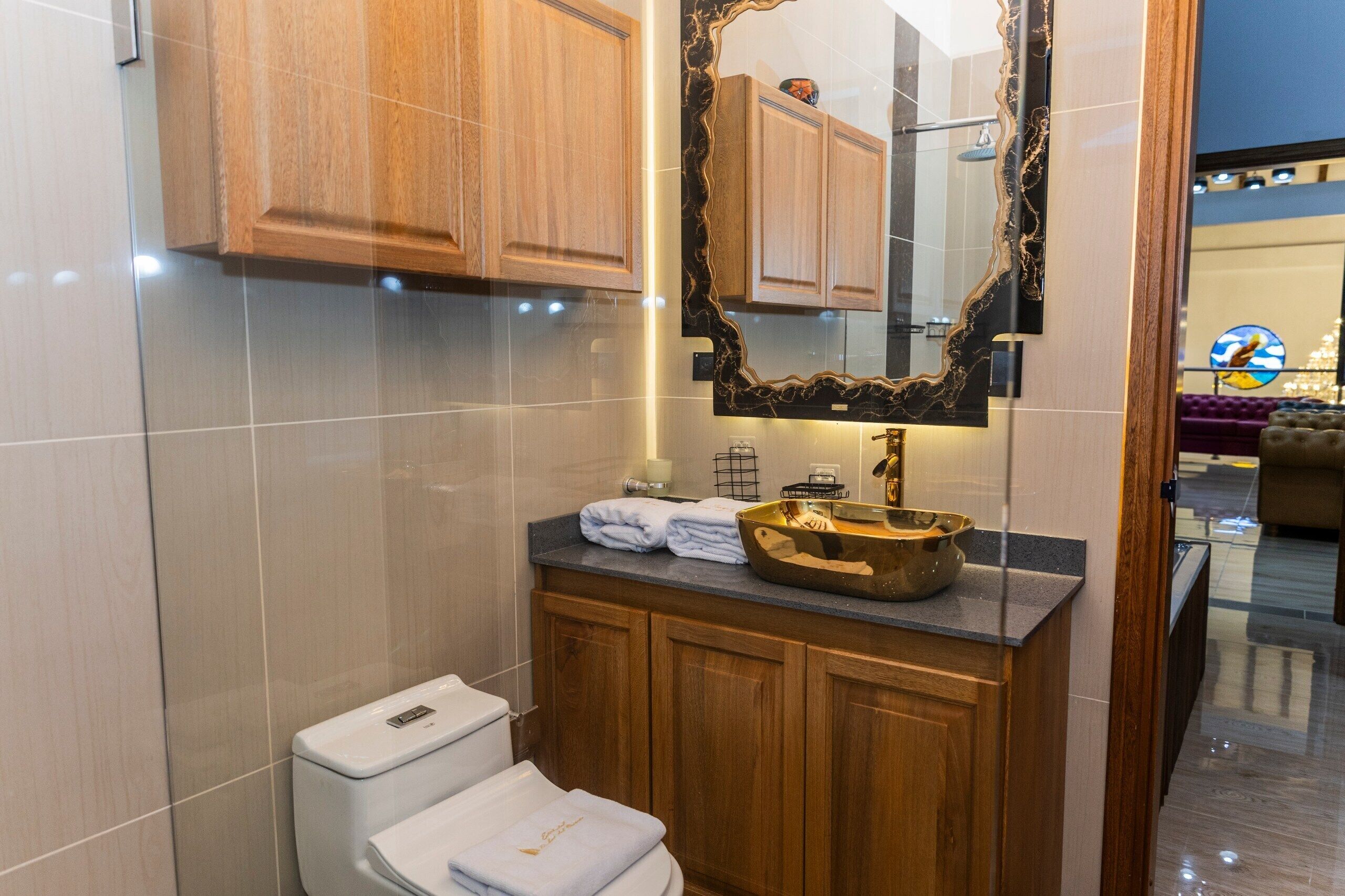 Een moderne badkamer met toilet, wastafel en een grote spiegel.