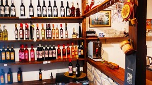 Ein Weinkeller mit Weinregalen, einer Holztheke und einer Steinwand.