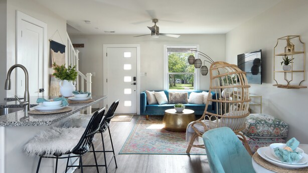 Eine moderne Küche mit Essbereich, einem blauen Sofa und einem dekorativen Stuhl.