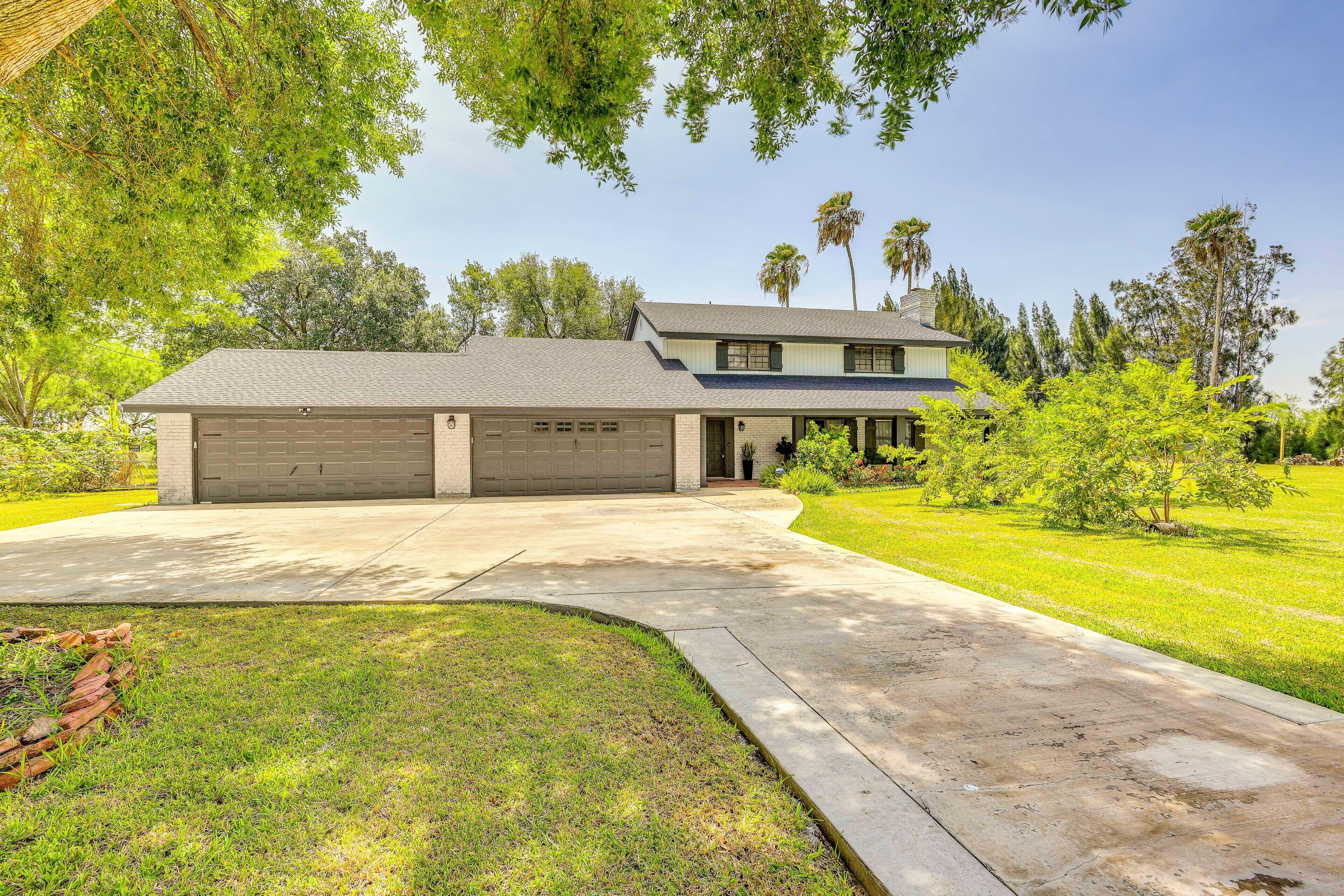 A two-story house with a garage, a covered porch, and a well-maintained lawn.