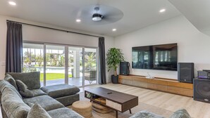 Ein modernes Wohnzimmer mit einer Eckcouch, einem Couchtisch, einem Fernseher und einem Lautsprecher.