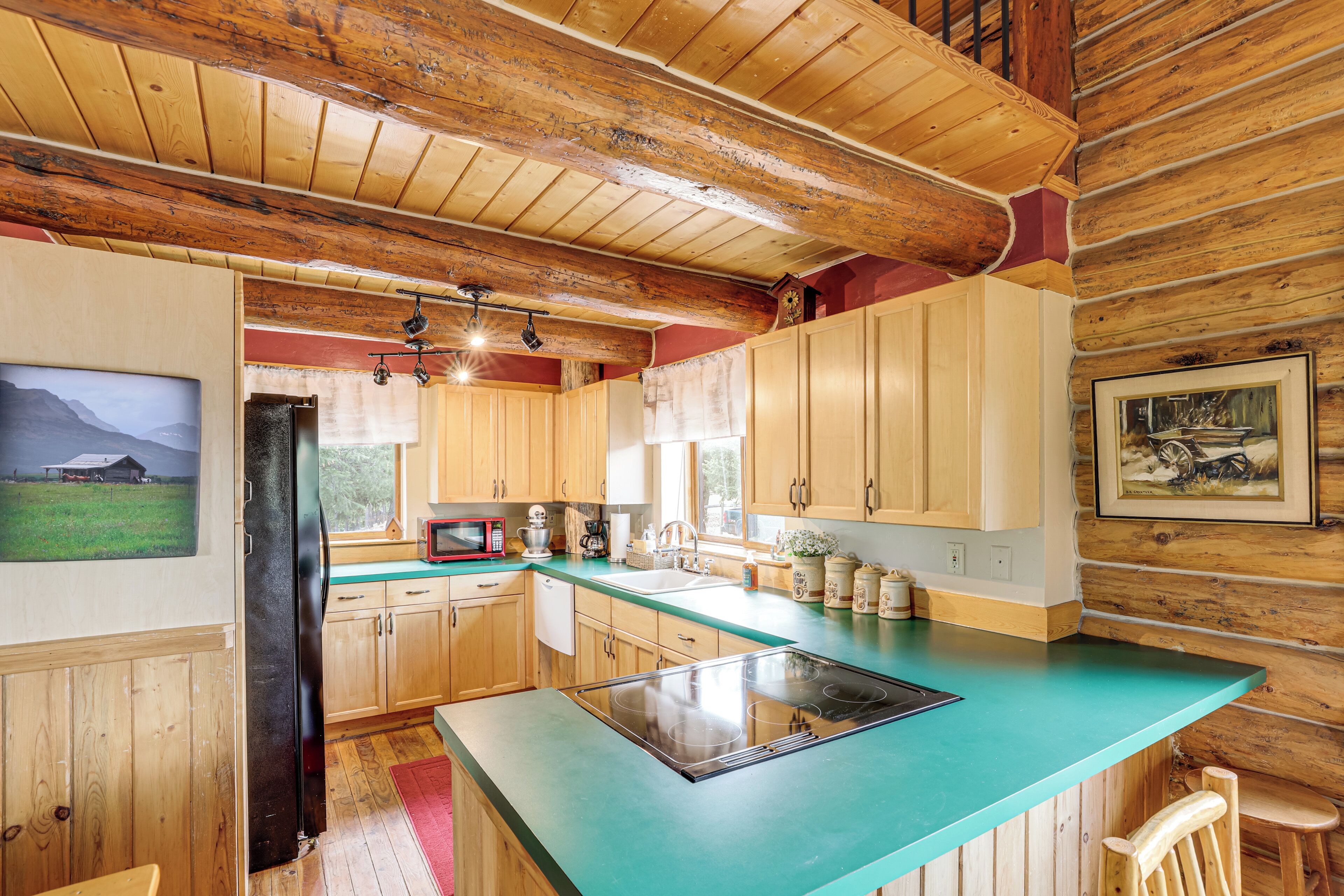 A kitchen with wooden cabinets, a turquoise countertop, a refrigerator, and a microwave.