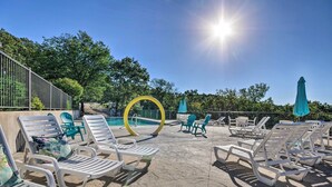 A poolside area with lounge chairs, a yellow decorative arch, and a clear blue sky.