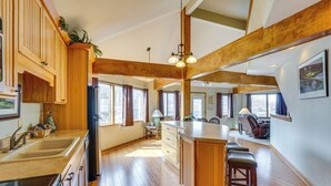 A spacious kitchen with wooden cabinets, a large island, and a dining area with bar stools.