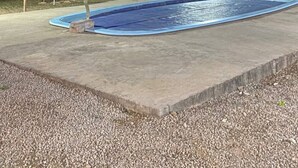 Una piscina rodeada de palmeras y un solárium de hormigón.
