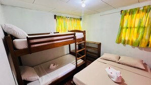 A bunk bed room with a wooden ladder, a small table, and a single bed with a pillow. - Sabores de mi Tierra (Popoyo)
