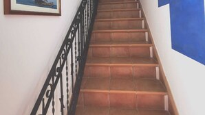 A staircase with a black railing, a framed picture of a sailboat, and a blue geometric wall design. - PortoRecanati Zimmer (Porto Recanati)