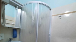 A bathroom with a shower enclosure, a sink, and a toilet. - PortoRecanati Zimmer (Porto Recanati)