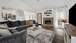 A living room with a fireplace, a sofa, a coffee table, and a TV. - Chateau Elan Family Home Retreat Fast WiFi Sleeps 15 (Hoschton)