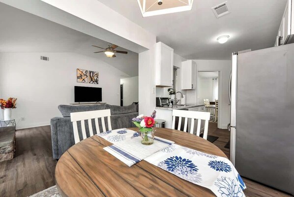 A modern kitchen with white cabinets, a built-in oven, and a stainless steel refrigerator.