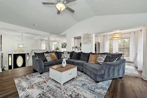 A spacious living room with a sectional sofa, a coffee table, and a ceiling fan. - Chateau Elan Family Home Retreat Fast WiFi Sleeps 10 (Hoschton)