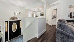 A modern interior with a staircase, a kitchen area, and a living space. - Chateau Elan Family Home Retreat Fast WiFi Sleeps 15 (Hoschton)