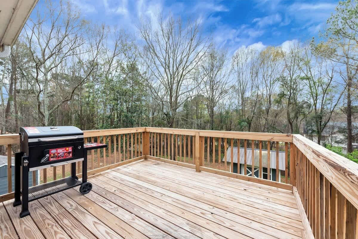 A wooden deck with a barbecue grill.