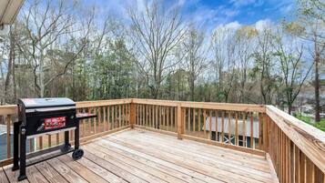 A wooden deck with a barbecue grill.