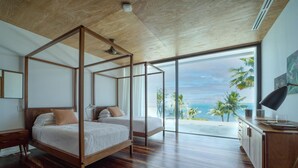 A four-poster bed with a view of the ocean, a wooden desk, and a large window. - The Beach House - Upscale 5-bed Beachfront Villa w Pool Pier Ocean Views (Placencia)