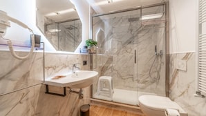 A modern bathroom with a marble sink, a glass shower enclosure, and a toilet. - Luxury Vatican Rooms (Rome)