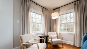 Une pièce avec deux chaises, une petite table et un lampadaire.