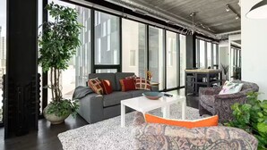 A modern living space with a sofa, coffee table, and patterned ottoman.