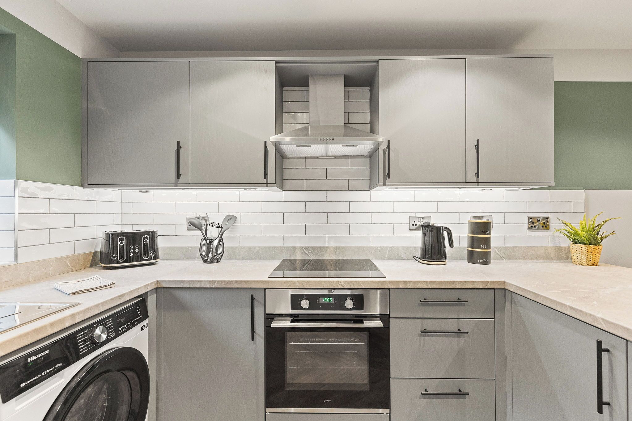 A modern kitchen with stainless steel appliances, a built-in oven, and a coffee maker.