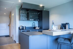 A modern kitchen with a built-in island, stainless steel appliances, and a glassware cabinet.