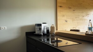 Eine moderne Küche mit integrierter Espressomaschine, einem Messerblock und einer Holzwandverkleidung.