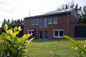 A two-story brick building with a flat roof, large windows, and a garage door.