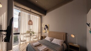 A modern bedroom with a bed, bedside tables, a desk, and a chair. - Artistic Hub / Gourmet District Loft, Chapinero Alto (Bogotá)