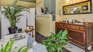 A bathroom with a sink, mirror, vanity, and plants. - The Kirkhouse Bed and Breakfast (Friday Harbor)