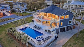 A multi-story house with a pool, balconies, and a covered deck area. - 7BR IOP Luxury - Porches, Pool, Spa and Ocean Views (Isle of Palms)