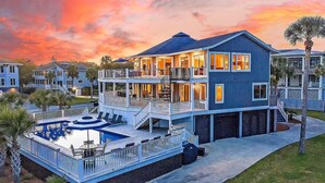 Une maison à plusieurs étages avec une piscine, des balcons et un garage.