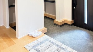 A room with a wooden floor, a black door, and a white closet with shelves.