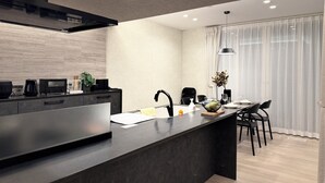 A modern kitchen with a central island, built-in appliances, and a dining area with a view. - Akikawa Ozu 1 | 15 min to TSMC | Entire 3LDK House | Up to 6 Guests (Ozu)