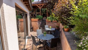 A patio with outdoor seating and a wooden pergola. - Hotel Kanarek (Prague)