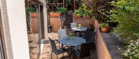 A patio with outdoor seating and a wooden pergola.