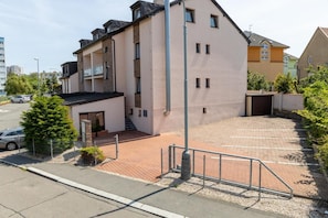 A multi-story residential building with a parking area in front. - Hotel Kanarek (Prague)