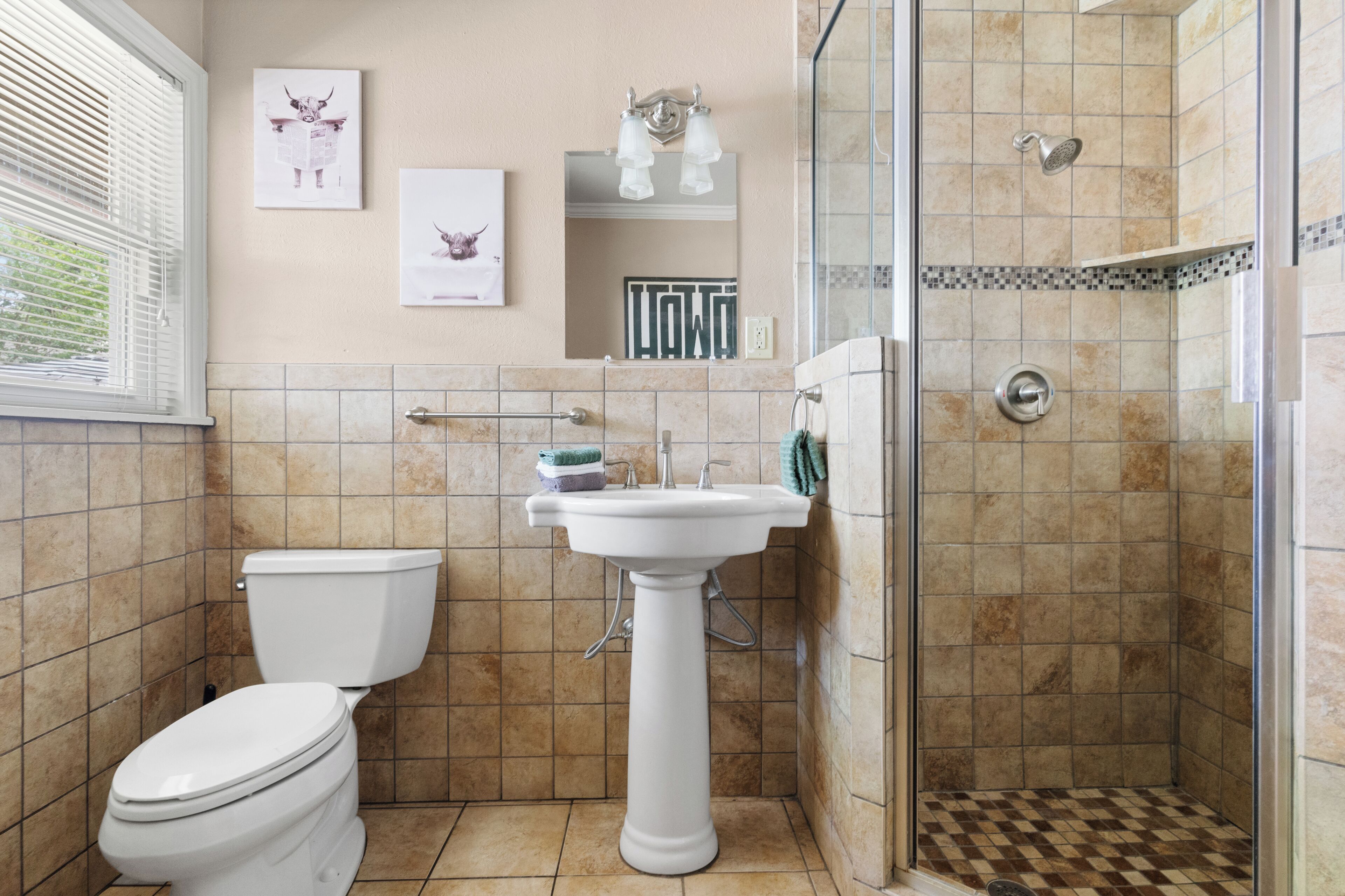 Une salle de bain équipée de toilettes, d’un lavabo et d’une douche.