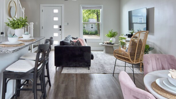 Ein modernes Wohnzimmer mit Essbereich, Deckenventilator und Blick ins Freie.