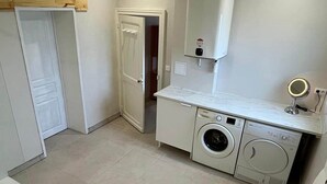 Une buanderie équipée d’un lave-linge, d’un sèche-linge et d’un miroir.