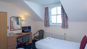 A hotel room with a bed, desk, chair, television, and a window with curtains. - Hydro Hotel (Llandudno)