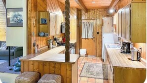 Un interior de madera con cocina, comedor y sofá.