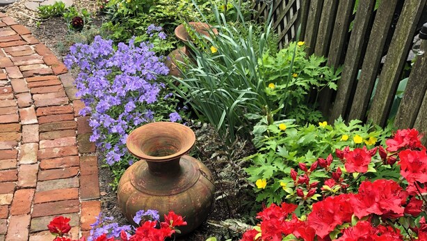 A garden with a brick path, a wooden fence, and various plants and flowers. - Spacious 4-bedroom house in beautiful Hoboken. 20 min to Manhattan and Soccer! (Hoboken)