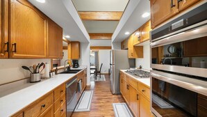 Una cocina moderna con armarios de madera, electrodomésticos de acero inoxidable y una isla central.