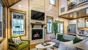 Ein gemütliches Blockhaus-Interieur mit Kamin, Holzwänden, Essbereich und Küche.