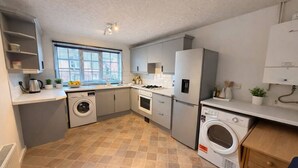 A compact kitchen with a washing machine, a stove, and a refrigerator. - Charming Flat • Great Location • Free Parking • Fast WiFi • Self-Check-In (Nottingham)